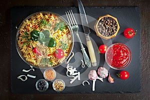 Pasta in a composition with accessories on the table, on an old background.