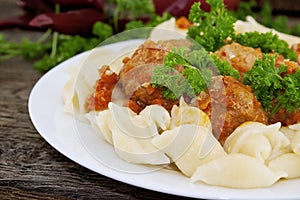 Pasta Conchiglie and meatballs with tomato sauce on rustic wooden background. Soft focus