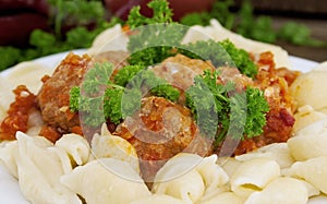 Pasta Conchiglie and meatballs with tomato sauce on rustic wooden background. Soft focus