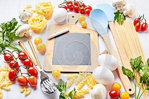 Pasta cooking background with chalkboard, tomatoes, herbs, mushrooms, eggs, top view. Italian cuisine concept