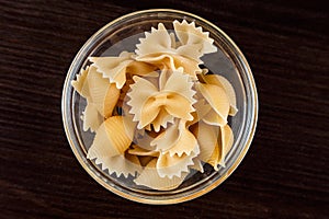 Pasta on dark wooden background in glass dishe close-up macro