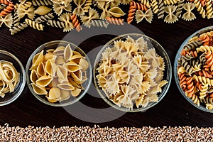 Pasta on dark wooden background in glass dishes close-up macro