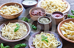 Pasta with different kinds of sauce on the wooden background