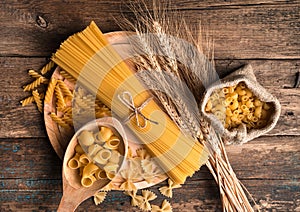 Pasta of different types on a wooden background. The view from the top.