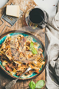 Pasta dinner with tagliatelle bolognese and red wine, top view