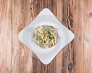 Pasta dish with a sour cream and herbs on wooden boards