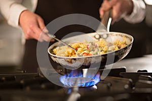 Pasta dish with vegetables on stove photo