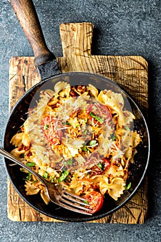 Pasta farfalle with roasted meat and tomatoes