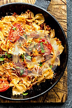 Pasta farfalle with roasted meat and tomatoes