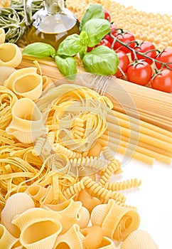 Pasta with fresh tomatoes, basil and olive oil on light shabby rustic background, top view, border. Pasta with
