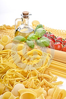 Pasta with fresh tomatoes, basil and olive oil on light shabby rustic background, top view, border. Pasta with