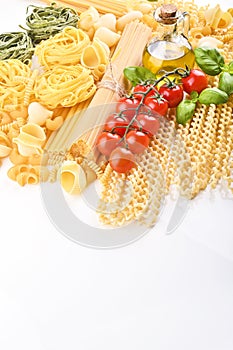 Pasta with fresh tomatoes, basil and olive oil on light shabby rustic background, top view, border. Pasta with