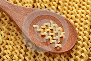 Pasta fusilli in a wooden spoon