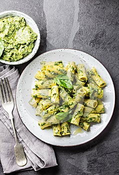 Pasta with green avocado herbs sauce. Top view, on slate