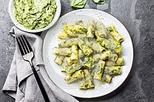 Pasta with green avocado herbs sauce. Top view, on slate