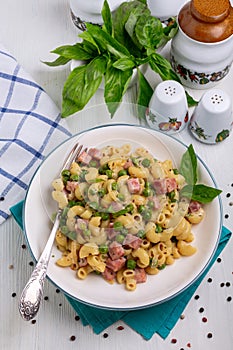 Pasta with ham, green peas and creamy sauce