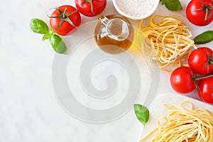 Pasta ingredients, above view corner border against a white marble background