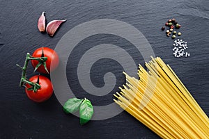 Pasta ingredients on black slate background