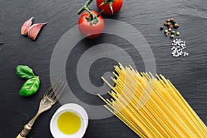 Pasta ingredients on black slate background