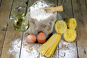 Pasta and Ingredients for Pasta on a Rustic Wooden Table