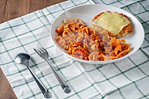 Pasta, Italian food, with tomato sauce topping with deep fried crispy pork cutlet and a sheet of cheese in white dish