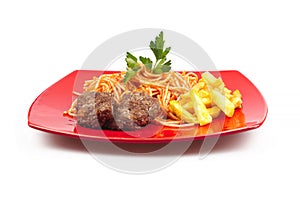 Pasta, meatballs and potatoes on a red plate on white background