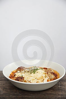 Pasta meatballs tomato sauce on wooden table