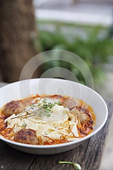 Pasta meatballs tomato sauce on wooden table