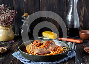 Pasta with meatballs and tomato sauce on a wooden background