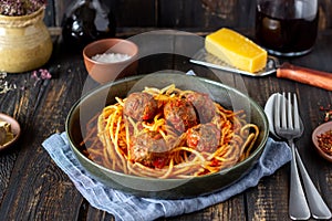 Pasta with meatballs and tomato sauce on a wooden background