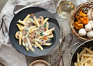Pasta with mushrooms on rustic tabletop.
