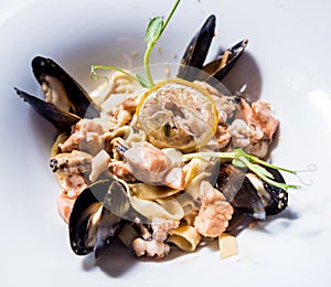 Pasta with mussels in pan. Italian style cuisine. Restaurant.