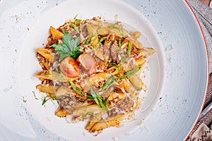 Pasta nautically with minced meat on wood table