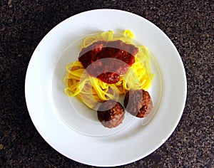 Pasta noodles in the sauce with meatballs in the oven.