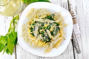 Pasta penne with spinach and nuts on board top