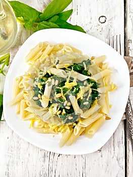 Pasta penne with spinach and nuts on light board top