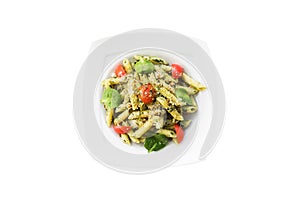Pasta with pesto sauce, fresh basil and nuts on white plate. Spaghetti isolated on white background