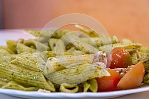 Pasta with pesto sauce and raw tomatoes