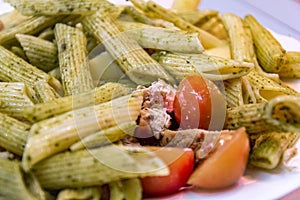 Pasta with pesto sauce and raw tomatoes