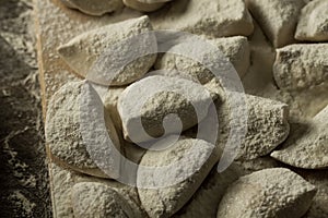 Pasta ravioli over wooden table with flour. kitchen utensils