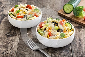 Pasta salad in a bowl on rustic wooden table
