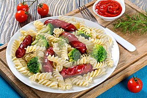 Pasta salad with broccoli and grilled sausages, close-up