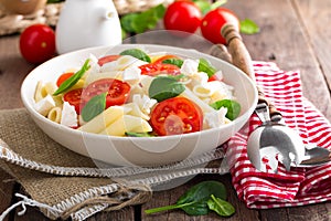 Pasta salad with fresh red cherry tomato and feta cheese. Italian cuisine