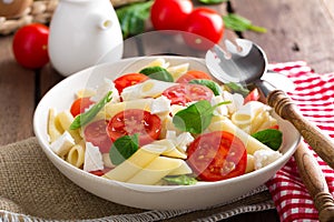 Pasta salad with fresh red cherry tomato and feta cheese. Italian cuisine