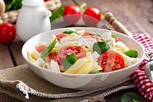 Pasta salad with fresh red cherry tomato and feta cheese. Italian cuisine