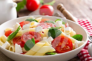 Pasta salad with fresh red cherry tomato and feta cheese. Italian cuisine