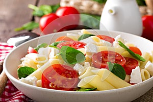 Pasta salad with fresh red cherry tomato and feta cheese. Italian cuisine