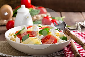 Pasta salad with fresh red cherry tomato and feta cheese. Italian cuisine