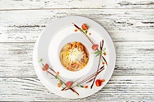 Pasta with sauce and tomatoes in a restaurant close-up. Italian pasta with microgreens on a white plate and copy space