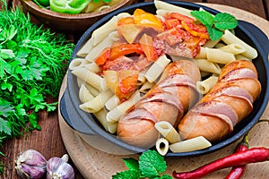 Pasta with sausages and lecho. Wooden rustic background. Selective focus. Top view